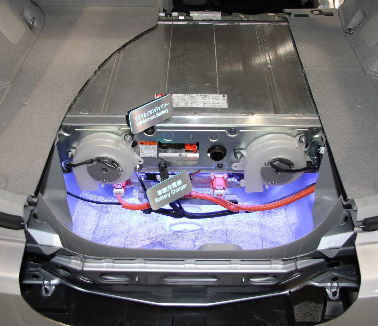 Figura H10. Instalarea unei baterii Prius PHV dintr-o generație anterioară, expusă în 2013. Carcasa, cablajul vizibil și traseele de aer ilustrează integrarea fizică, fără a defini toate bateriile Prius. Foto: TTTNIS, Wikimedia Commons, Public domain dedication. Vezi atribuirea imaginilor.